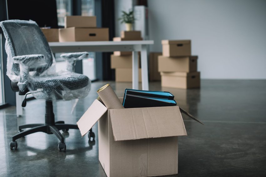 cardboard box with folders and office supplies in floor during r